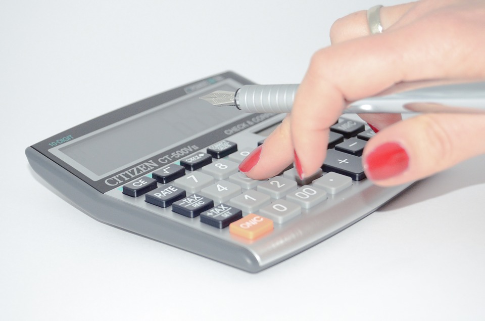 Women using a calculator and using a pen