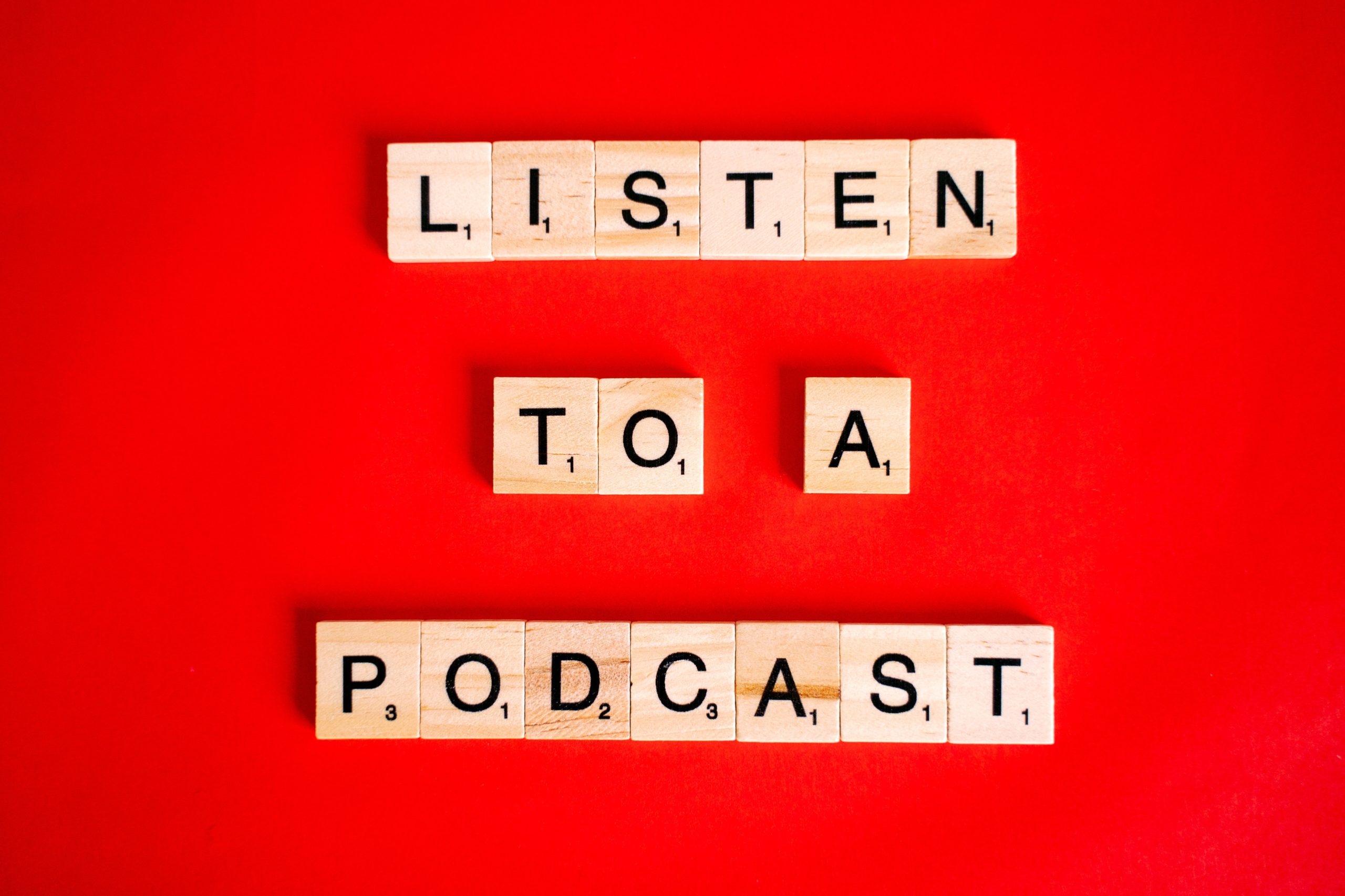 Text “Listen to a podcast” written on Scrabble tiles.