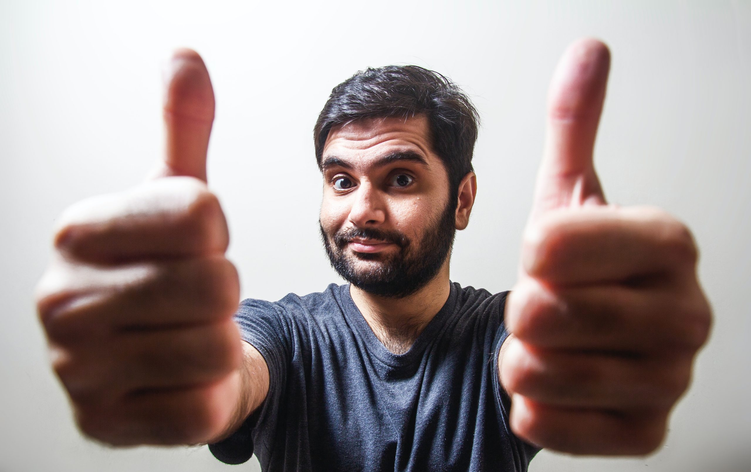 A man makes a thumbs up sign with both hands.