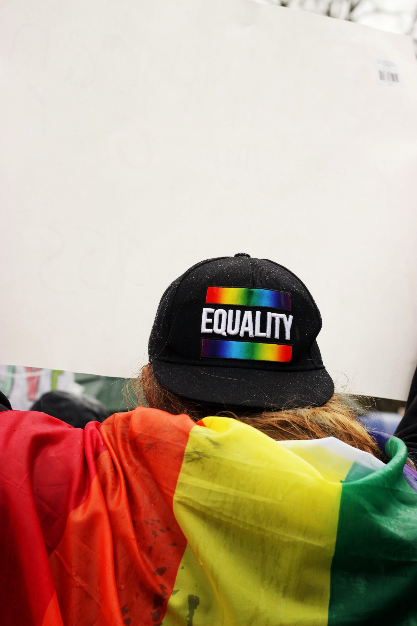 A person wearing a cap with the word equality written on it.