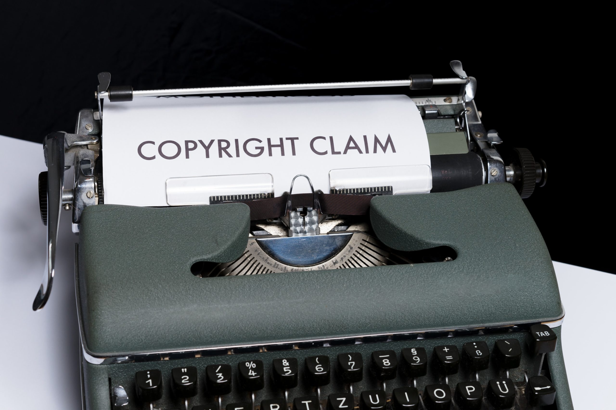 A typewriter with a piece of paper in the carriage with the words “copyright claim” typed on it.