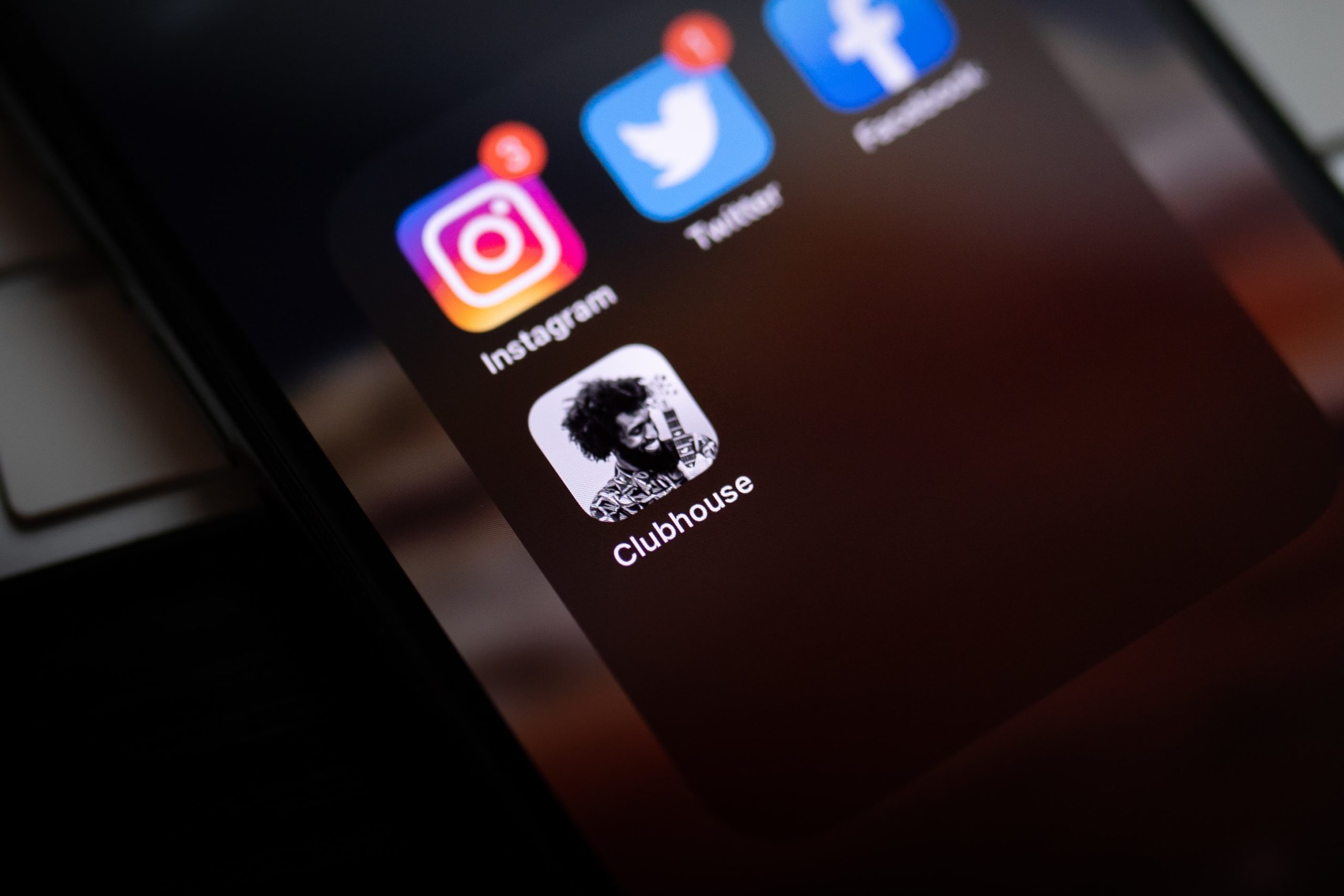 Image of a mobile device with the Clubhouse social media app icon on the screen.