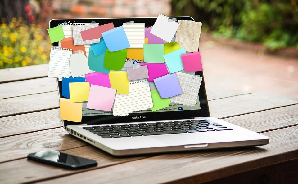 A laptop with sticky notes all over its screen