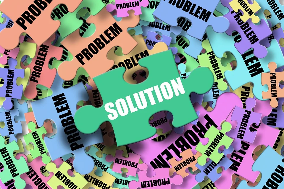 Puzzle pieces with the word “problem” and one piece with the word “solution” written on them