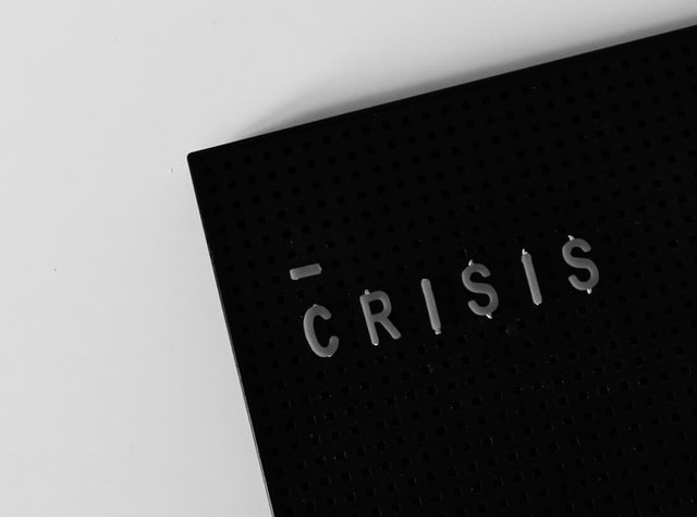 The word “CRISIS” written on a black tablet.