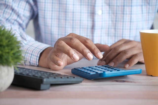 A person calculating cost on a calculator