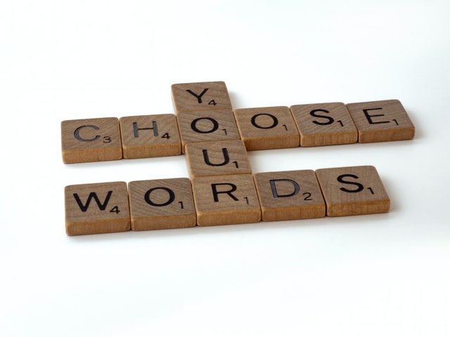 “Choose your words” spelled out in wooden tiles
