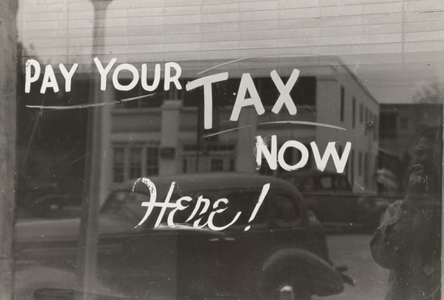 Sign reading “Pay your tax now here”